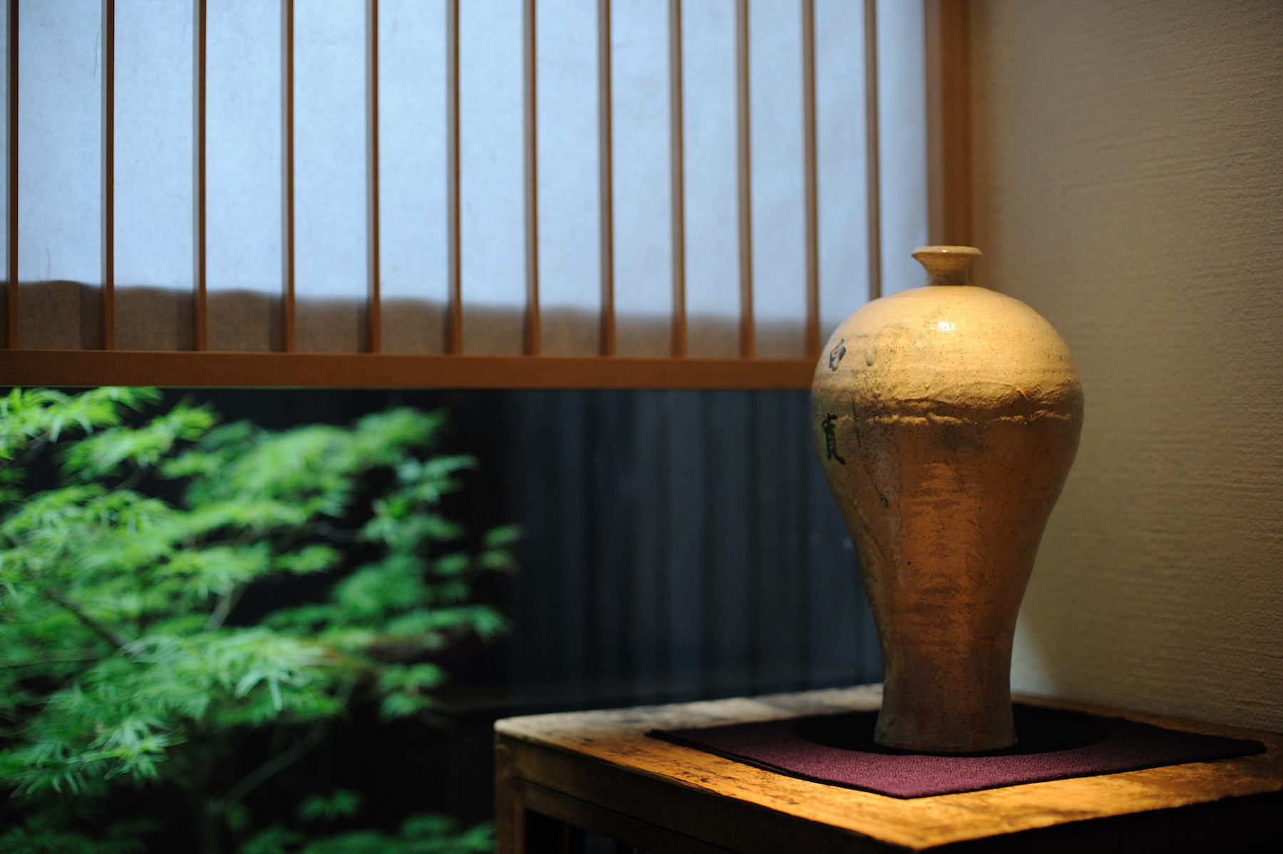 Japanese interior detail with ceramic vase and garden view.