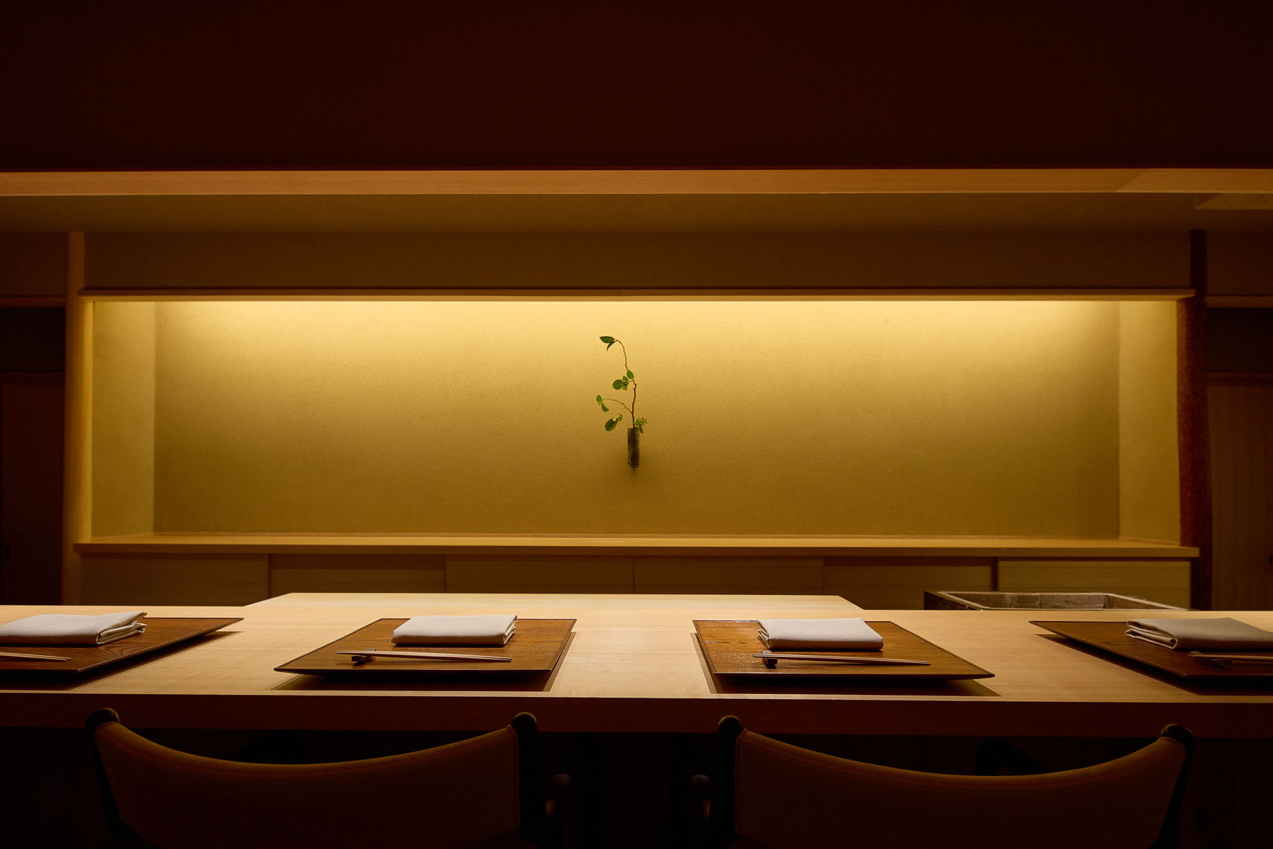 High-end Japanese dining counter with quiet warm light.